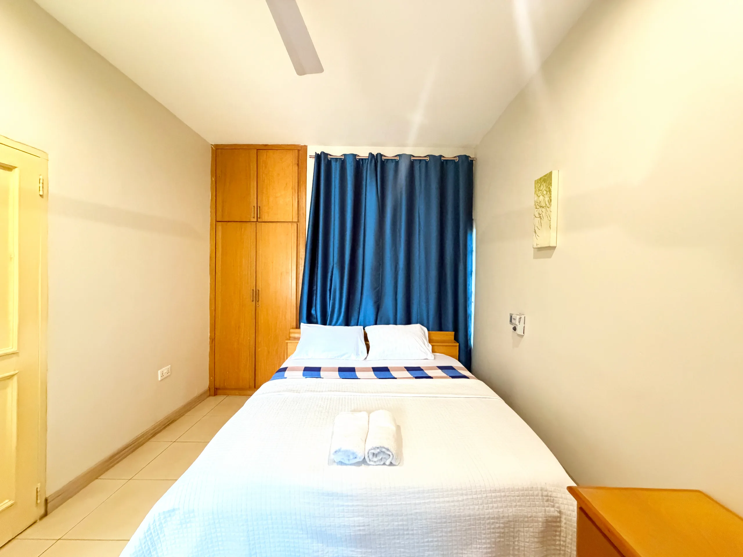 A bedroom made up with fresh linen and towels