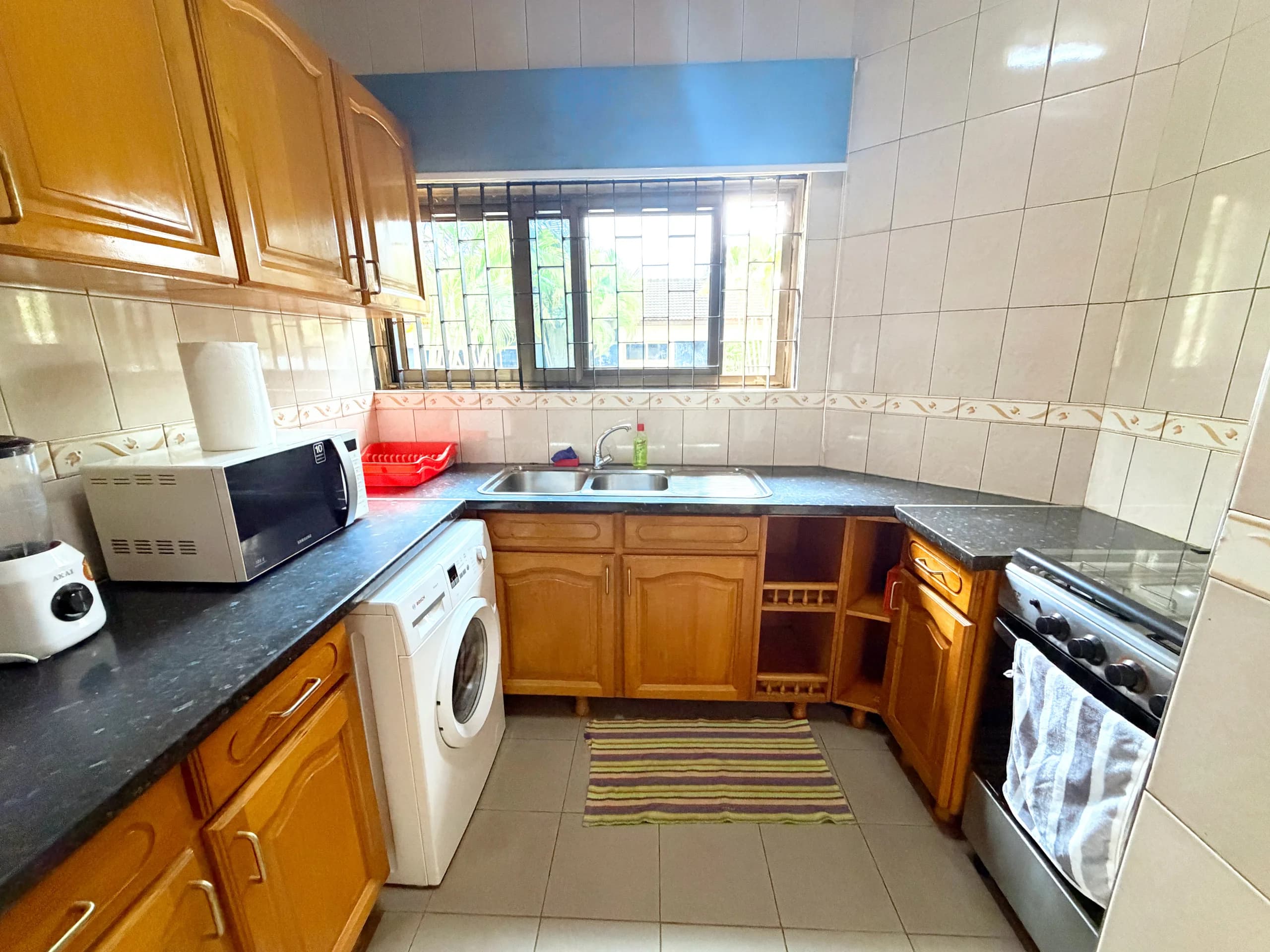 A kitchen worktop with cooker, microwave and washing machine