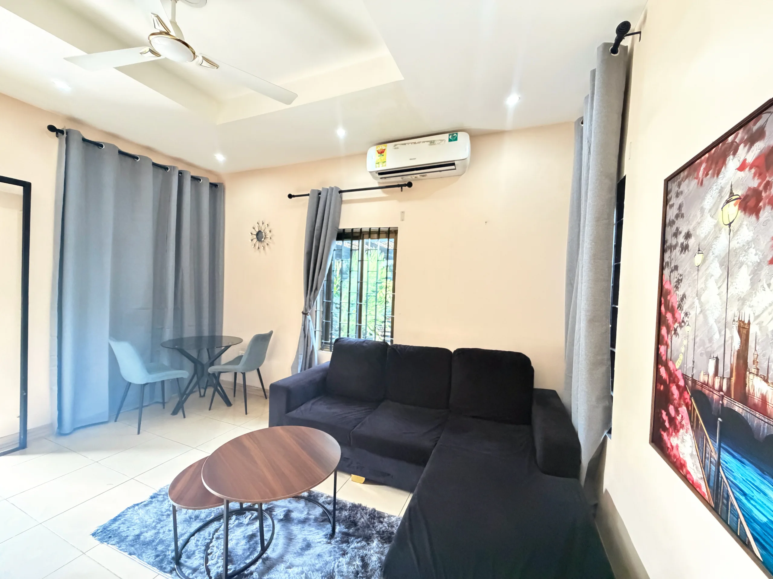 A living room with a charcoal sofa and low tables
