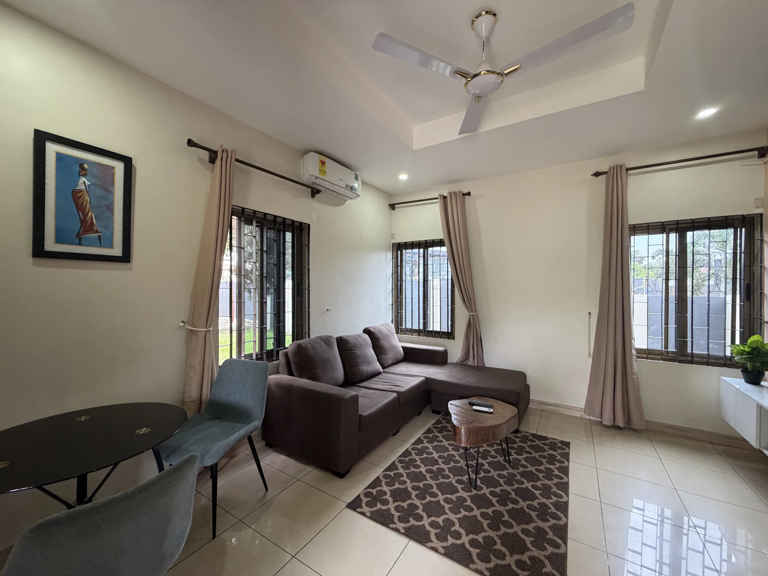 A living room with a grey sofa and dining table