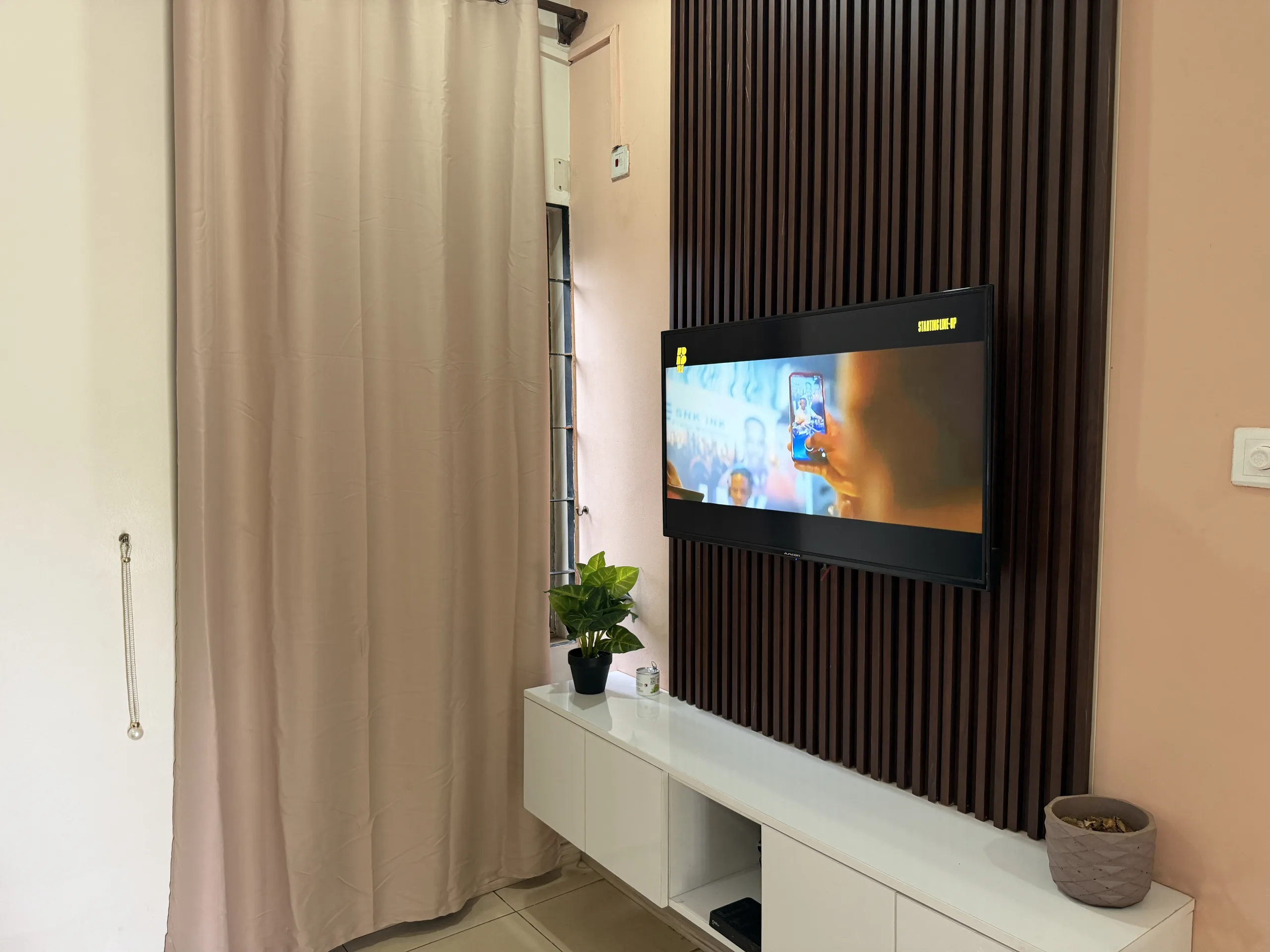 A television set into a slatted timber panel